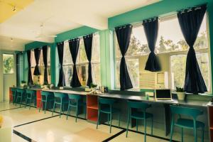 bar z niebieskimi stołkami i oknami w obiekcie Zostel Pushkar w mieście Pushkar