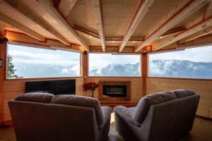 ein Wohnzimmer mit 2 Stühlen und einem TV in einem Haus in der Unterkunft DalaiLama Village in Antey-Saint-André