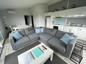 a living room with a gray couch and a table at Creek to Beach in Apollo Bay