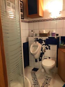 ein Badezimmer mit einem WC, einem Waschbecken und einem Urinal in der Unterkunft Wohnstudio in umgebauter Scheune in Altlassing