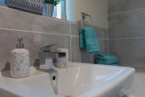 ベルファストにあるCity Centre Apartmentの石鹸ディスペンサーが付いたバスルームのシンク +24枚の写真