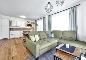 een woonkamer met een bank en een keuken bij Panorama Lodge Alpine Living 201 in Tauplitz