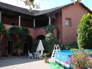 a house with a patio and a table and an umbrella at B&B Locanda Tempi Lontani Adults Only in Orta San Giulio
