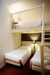 two beds in a room with two bunk beds at Le Relais Du Roy in Le Mont Saint Michel