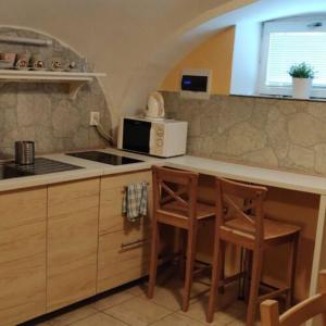 a kitchen with two chairs and a counter with a stove at Hotel Jeleň in Pezinok