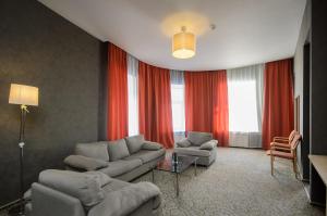 una sala de estar con sofás, sillas y cortinas rojas. en 5th Corner Hotel, en San Petersburgo