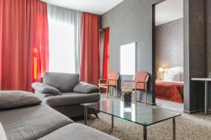 un soggiorno con divano, tavolo e letto di 5th Corner Hotel a San Pietroburgo