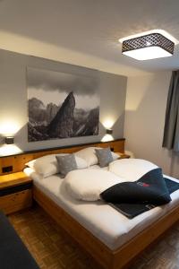 1 dormitorio con 1 cama con una pintura en la pared en LUSE Living, en Maurach
