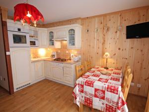 a kitchen with a table with a red and white table cloth at Appartement Valloire, 3 pièces, 4 personnes - FR-1-263-206 in Valloire