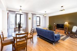 a living room with a blue couch and a table at hotelise I Snowbowl Apartment in Tsaghkadzor