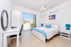 a bedroom with a bed and a desk and a mirror at Villa Elaine in Protaras