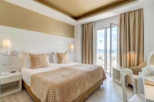 a hotel room with a bed and a large window at Hotel Illa d'Or & Club Apts 4* Sup in Port de Pollensa