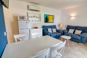 Una cocina y una sala de estar con un sofá y una mesa. en Apartamentos Las Golondrinas, en Cala'n Bosch