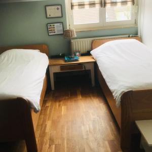 a room with two beds and a desk in it at Beej Fliep in America