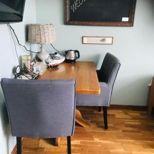 een houten tafel met twee stoelen en een lamp erop bij Beej Fliep in America