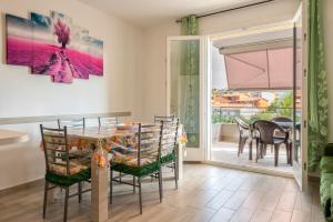 a dining room with a table and chairs and a balcony at Ligure apartment in Alghero