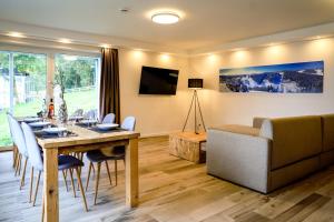 uma sala de estar com uma mesa de jantar e um sofá em Smart Resorts Haus Opal Ferienwohnung 401 em Winterberg