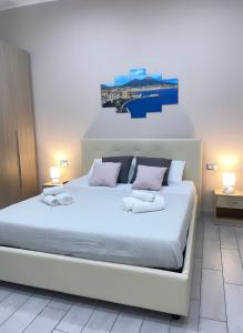 Antonio’s house في نابولي: غرفة نوم بسرير ابيض عليها منشفتين