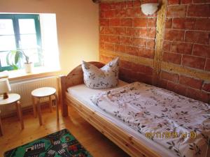 a bedroom with a bed and a brick wall at Ferienhof Herm in Glashütte