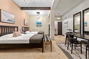 Rincon Plaza Hotel في رينكون: غرفة نوم بسريرين وطاولة طعام