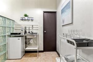 a small kitchen with a sink and a door at Rincon Plaza Hotel in Rincon