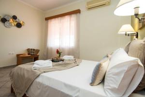 a bedroom with a white bed and a window at Spira Studios & Apartments in the Heart of Laganas in Laganas
