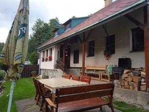 un patio con una mesa y una sombrilla junto a una casa en Chalupa Benecko-M.86, en Benecko