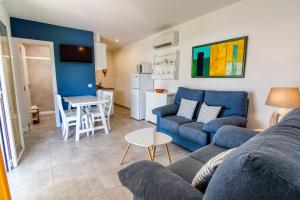 una sala de estar con un sofá y una mesa en Apartamentos Las Golondrinas, en Cala'n Bosch