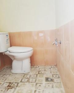 a bathroom with a toilet and a tile floor at Losmen 2000 Tiga in Yogyakarta