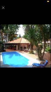 a large blue swimming pool with two chairs and a house at landmark karon in Karon Beach