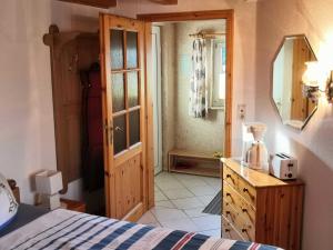 Schlafzimmer mit einem Bett, einer Kommode und einem Spiegel in der Unterkunft Bungalow Poggendorf in Eldena