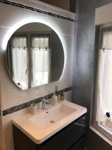 a bathroom with a sink and a mirror at Les Aubennes in Fromelennes