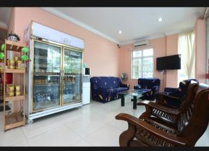 un salon avec des chaises bleues et une télévision dans l'établissement SA VILLA HOLIDAY INN, à Kota Bharu