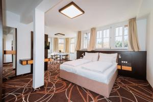 a bedroom with a large bed and a dining room at Hotel Hubertus in Karlovy Vary