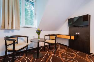 Televízia a/alebo spoločenská miestnosť v ubytovaní Hotel Hubertus