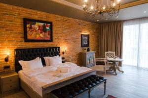 a bedroom with a large bed and a brick wall at Art Club in Baku