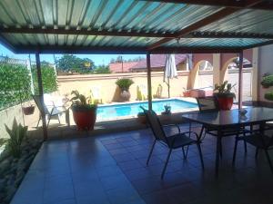 a patio with a table and chairs and a pool at Joezebel Guesthouse in Mogwase