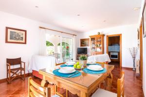 Il comprend une cuisine et une salle à manger avec une table et des chaises en bois. dans l'établissement Villa Xiscu by Mauter Villas, à Ciutadella