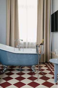a bath tub sitting in a room next to a window at Hotel Ruth, WorldHotels Crafted in Stockholm