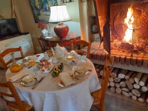 uma sala de jantar com uma mesa e uma lareira em Aux Glycines em Marcilly-Ogny