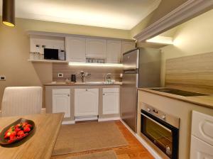a kitchen with white cabinets and a bowl of fruit on a table at Hotel Balestri - WTB Hotels in Florence
