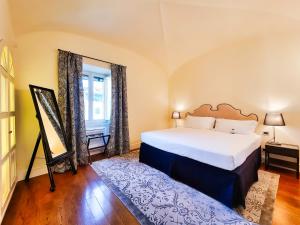 a bedroom with a large bed and a mirror at Hotel Balestri - WTB Hotels in Florence