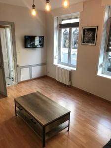 a living room with a coffee table and a tv at Centr’Appart. in Saint-Omer