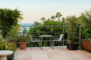 un patio con tavolo, sedie e vista sull'oceano di City Centre Rooms a Limassol