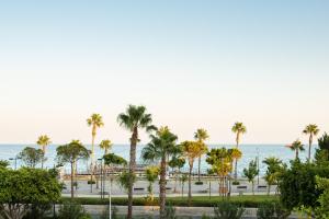 a view of the beach and palm trees at City Centre Rooms in Limassol