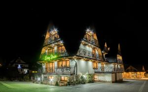 a large building with lights on it at night at Leśny Dwór in Murzasichle +74 photos