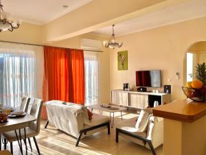 a living room with a couch and a table and chairs at Nissaki Jonas Apartment in Nisakion