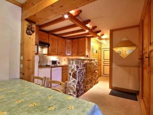 a kitchen with wooden cabinets and a table and a counter at Appartement La Plagne, 2 pièces, 4 personnes - FR-1-455-122 in La Plagne