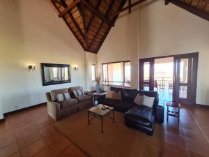 a living room with a couch and a table at Zebula No 2 Waterbergs Over the Savannah 4 Bedroom in Mabula