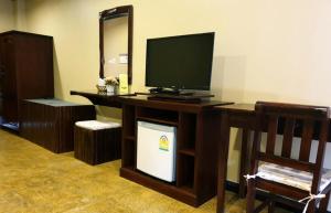 Habitación con escritorio y TV. en Andaman House SHA Plus, en Patong Beach